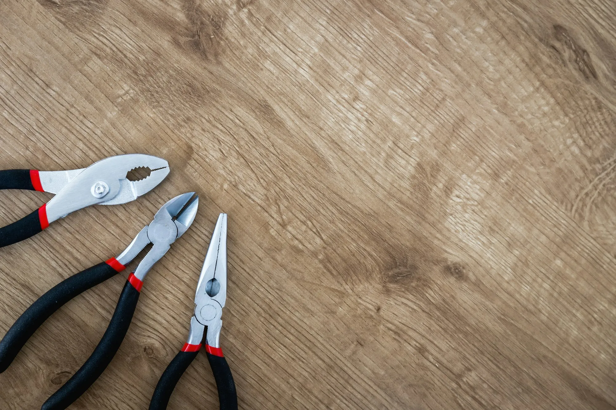 Pliers lying on a wooden work surface