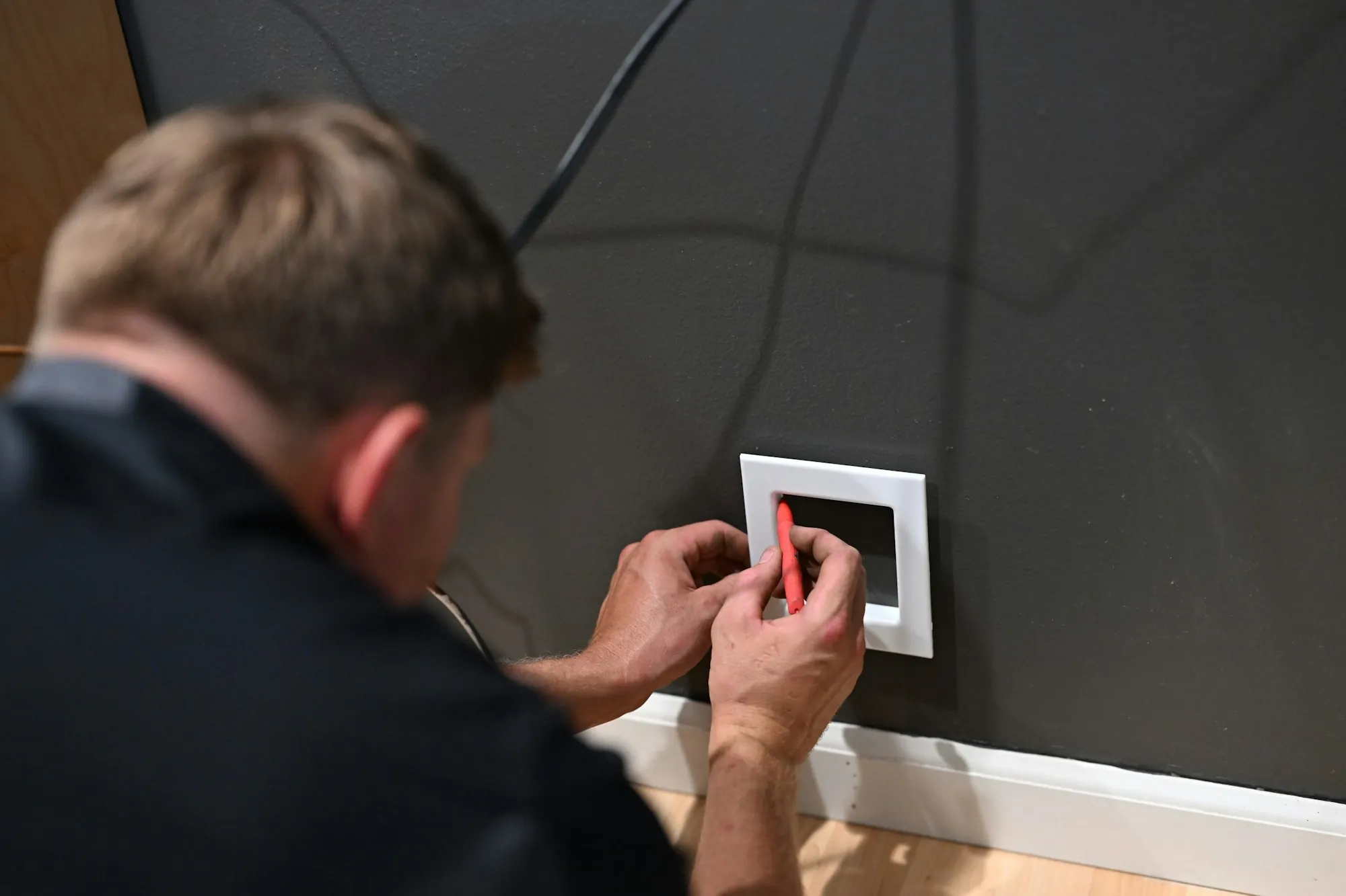 Electrician fitting a cover plate on a new wall switch