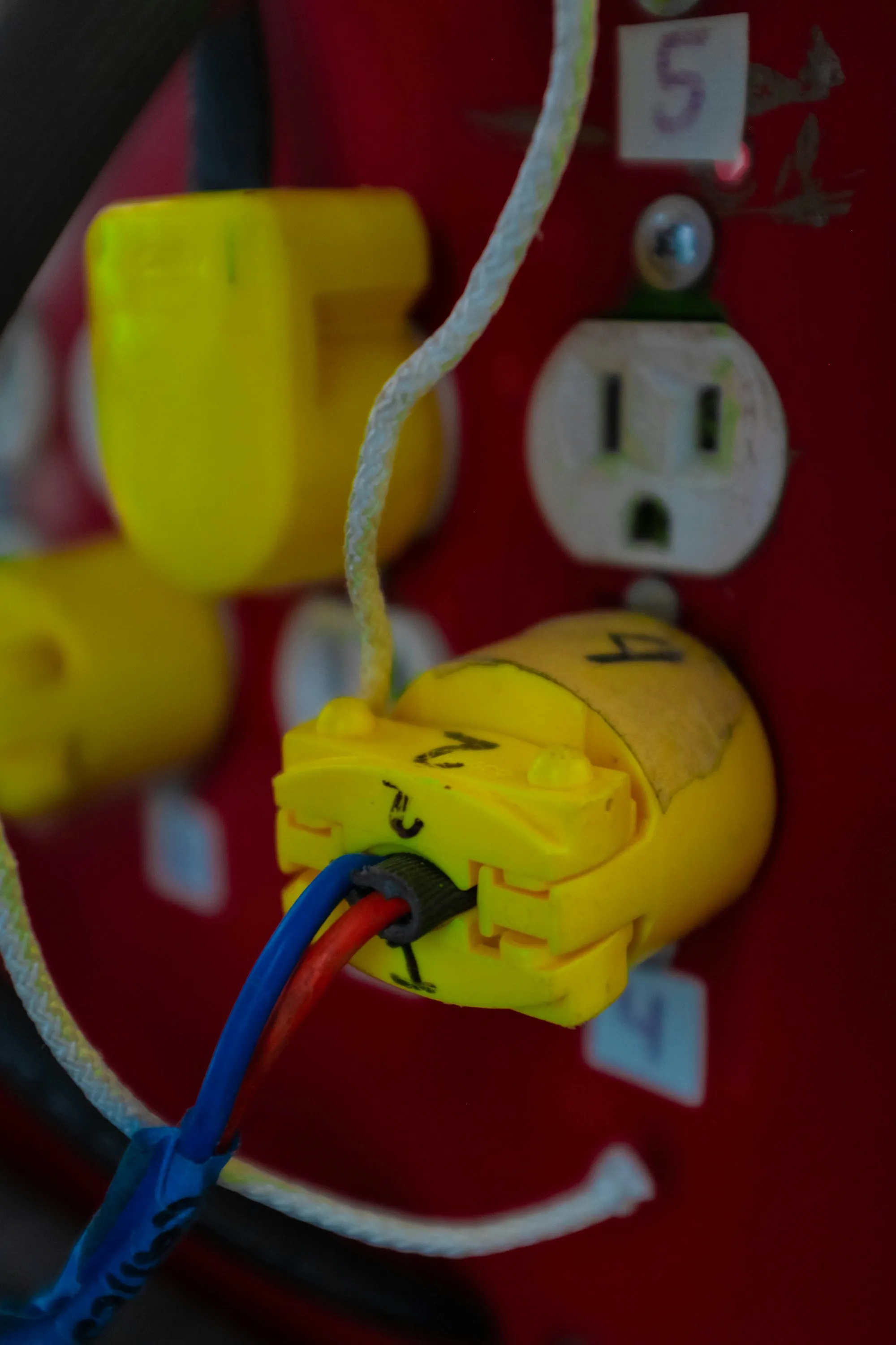 Red wall outlet with a yellow plug inserted