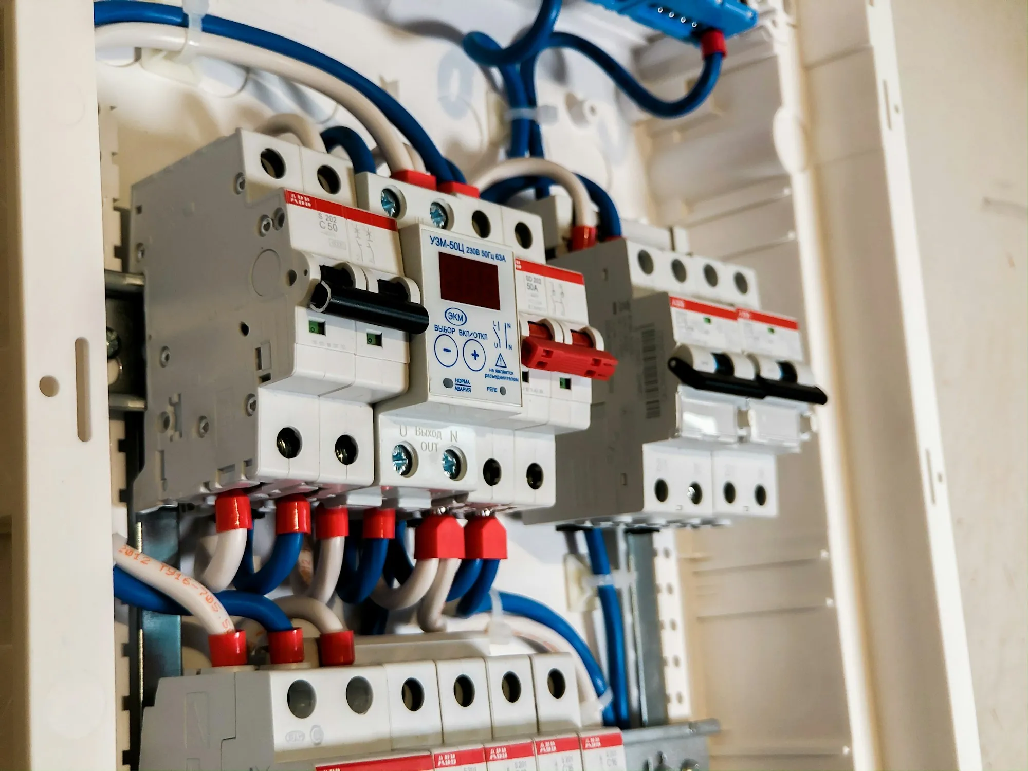 Row of modern circuit breakers with neatly connected wiring