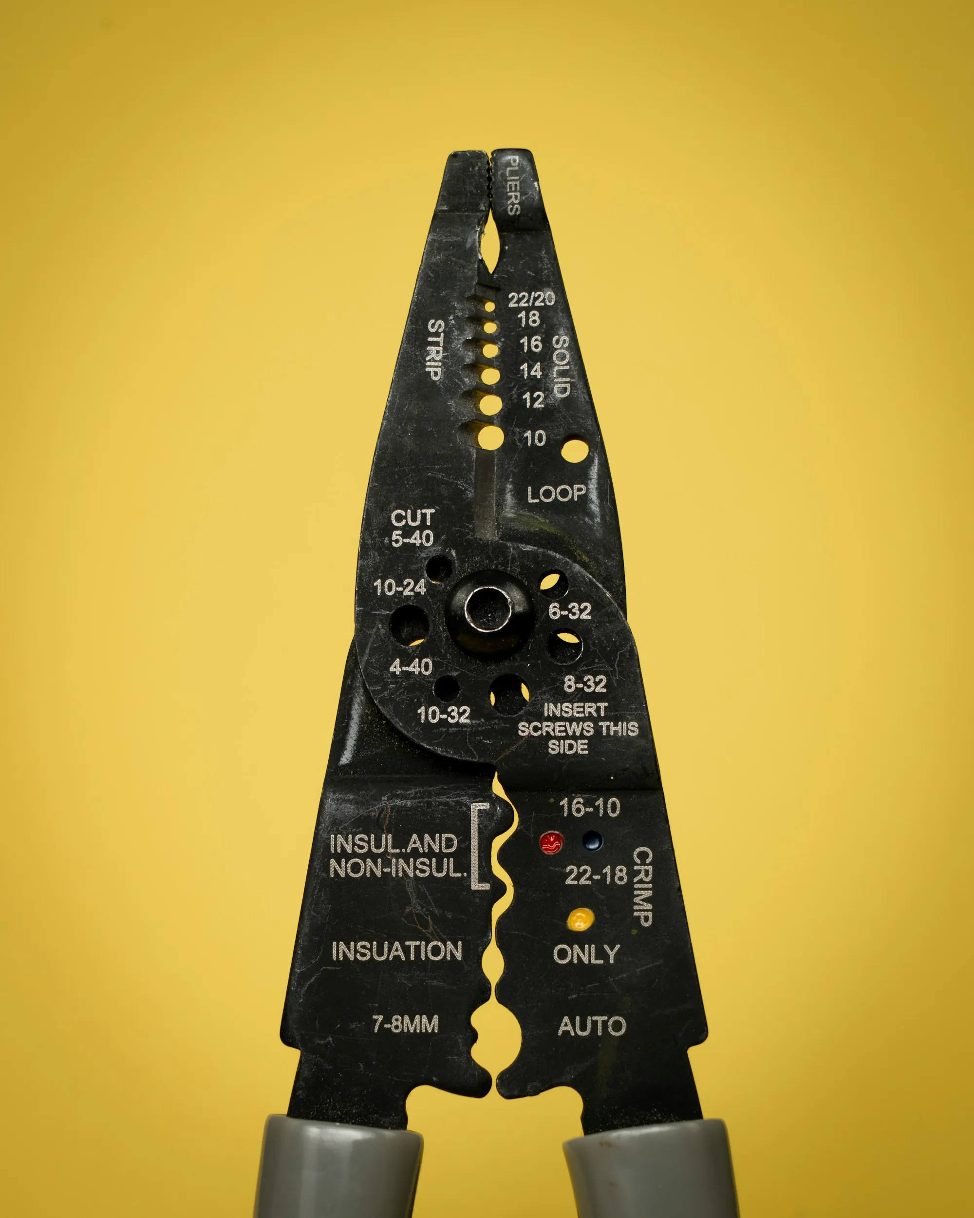 Wire stripping tool against a yellow background